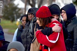 Alex Hare hugs family friend Mbele Badawi at the rally on Thursday evening. - PHOTO BY MATT DETURCK