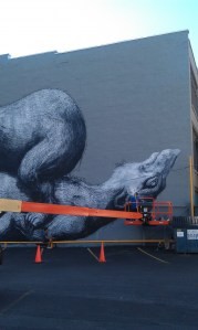 Belgian artist ROA’s mural for “Wall\Therapy” is almost finished on the building facing the World Wide News lot at 100 St. Paul Street. PHOTO BY REBECCA RAFFERTY