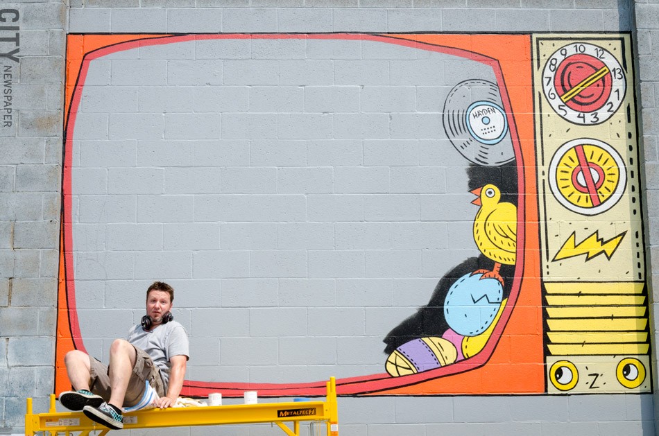 John Perry works on his piece in the Public Market. - PHOTO BY MARK CHAMBERLIN