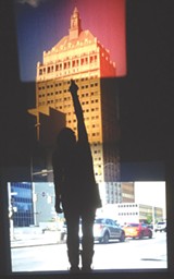 PHOTO PROVIDED - Tara Merenda Nelson's "End of Empire" (seen here with a viewer's silhouette) is a projected collage of the Kodak tower using four formats of film. Nelson's show, "Light Sensitive," is currently on view at Visual Studies Workshop.