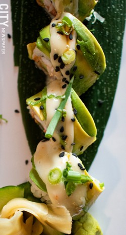 The Johnny Cashew roll consists of smoked salmon, steamed shrimp, cashew butter, and cucumber, and then topped with avocado, eel sauce, and sprinkled with black sesame and scallions. - PHOTO BY JACOB WALSH