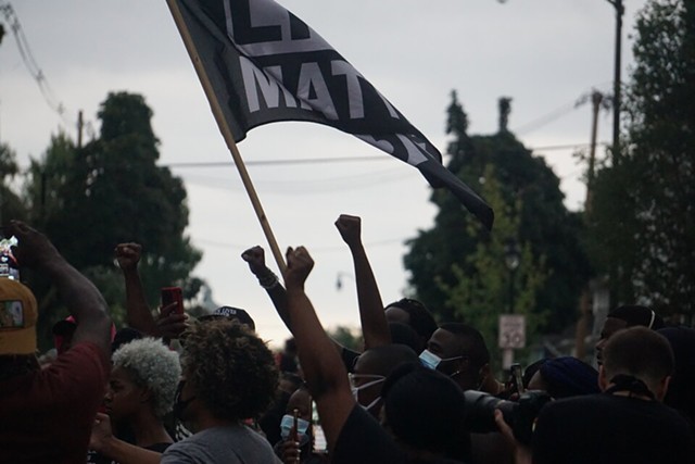 Protesters wave a Black Lives Matter flag on Jefferson Avenue. - PHOTO BY GINO FANELLI