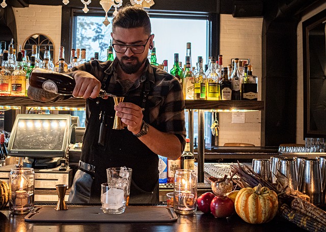 The Revelry's bar manager Mack Hartman adds the clove and brown sugar syrup to "The Iron Sickle." - PHOTO BY JACOB WALSH