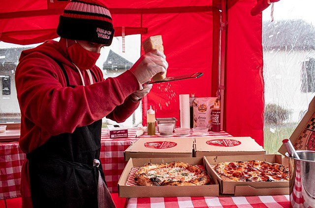 Luis Perez makes some pizzas in an enclosure adjacent to his converted Piaggio Ape P601 - PHOTO BY JACOB WALSH