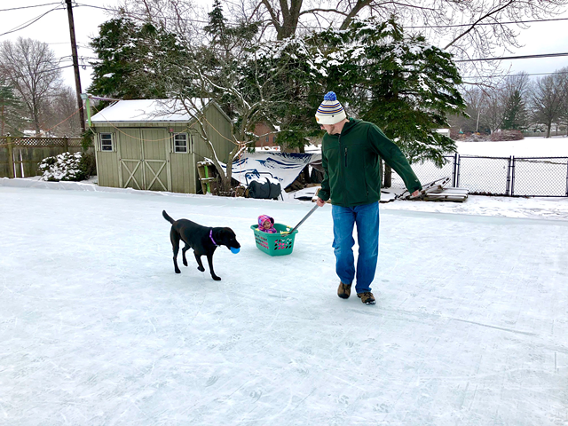 Joseph Climek slides his daughter around on "Mos Iceley," his backyard rink in Webster. - PHOTO COURTESY OF JOSEPH CLIMEK AND MELODY KING