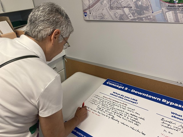 Maria Furgiuele, executive director of the Community Design Center of Rochester, makes notes under an Inner Loop fill-in concept. - PHOTO BY JAMES BROWN