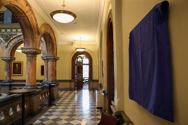 On Nov. 30, 2021, a day before Mayor Lovely Warren was to resign from office, her official portrait hung in the atrium at City Hall under a royal blue cloth waiting to be unveiled. - PHOTO BY MAX SCHULTE