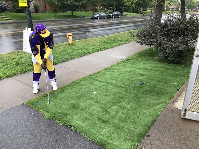 Anthony (Tony) Lovett used a patch of artificial turf outside the Lake Avenue Mini Market to practice his putting. - PHOTO BY DAVID ANDREATTA