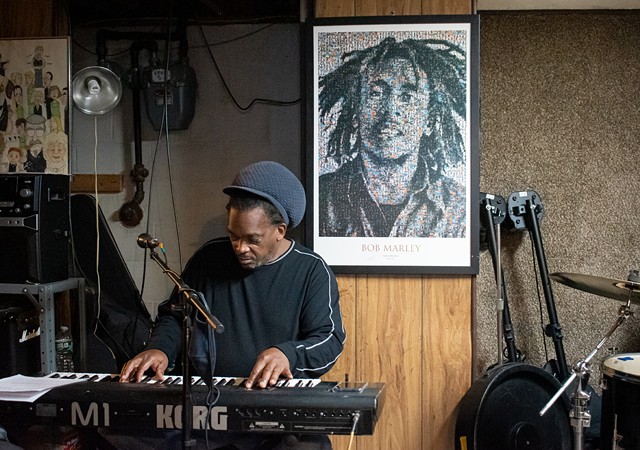 A poster of reggae icon Bob Marley hangs on the wall as Ronnie "Skill" Gordon rehearses with Ignite Reggae Band. - PHOTO BY JACOB WALSH