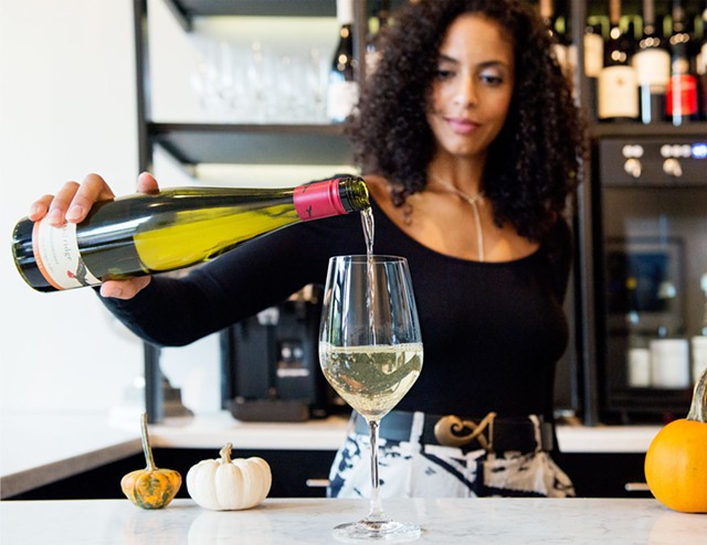 Apogee owner Simone Boone pours a glass at her popular Park Avenue wine bar. - PHOTO BY AMY MOORE