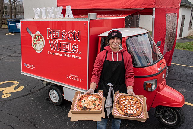 Luis Perez with a couple of Neapolitan pizza pies outside his Peels on Wheels Piaggio Ape - PHOTO BY JACOB WALSH
