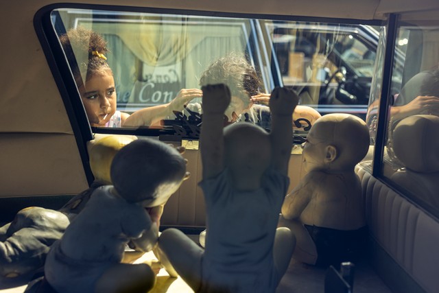 Children peer through the window of a hearse at the End of Summer Car Show & Motorcade. - LAUREN PETRACCA