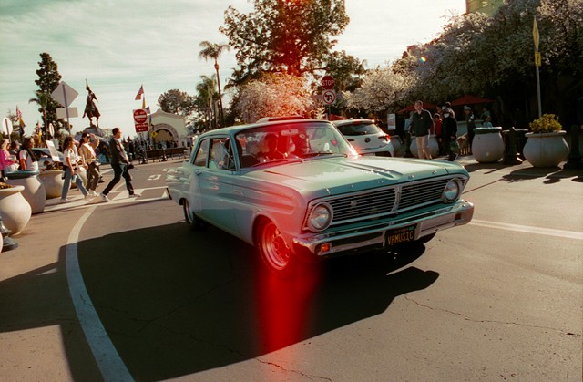 A photograph shot on CineStill 800T film shows a red spark of halation off the car windshield and a light leak down the middle. - ROBERTO FELIPE.