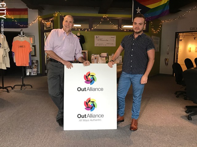 Gay Alliance Executive Director Scott Fearing (left) and Education Coordinator Rowan Collins, with the organization’s new logo and signage. - PHOTO BY RYAN WILLIAMSON