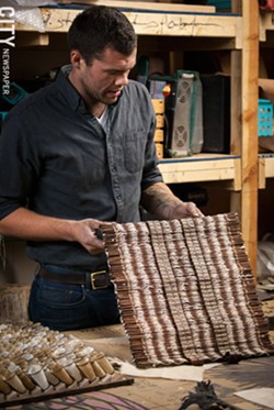 Kinz-Thompson with his deconstructed book sculptural wall pieces in his Hungerford studio. - PHOTO BY RYAN WILLIAMSON