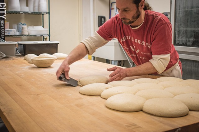 An Amazing Grains worker prepares bread dough. - PHOTO BY JACOB WALSH