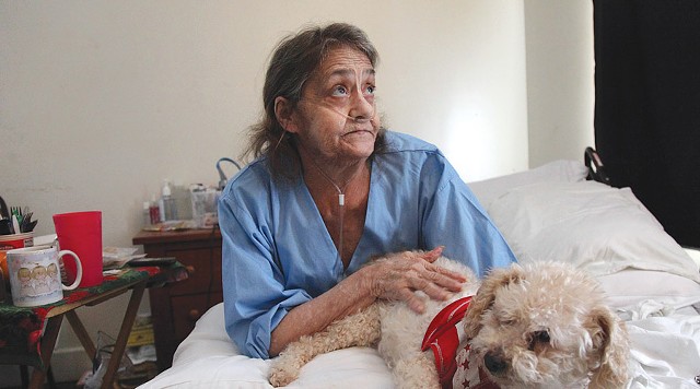 Linda Barger sits in the bed of her Sherman Street apartment with her dog, Bear, on January 16.