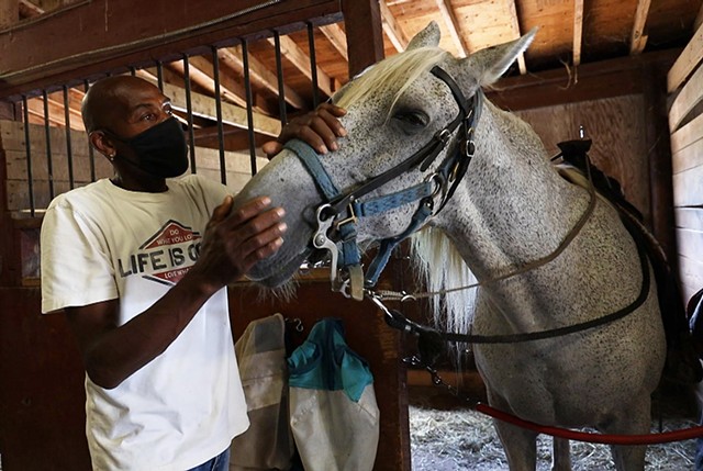 Matthew Doward tends to one of the horses at his program, A Horse's Friend, which provides many kids with their first experience with the animals.