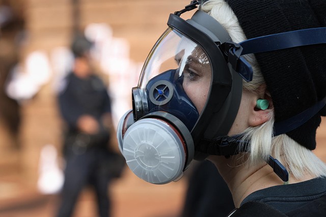A protester wears a gas mask during a standoff with Rochester police outside City Hall on Sept. 16.