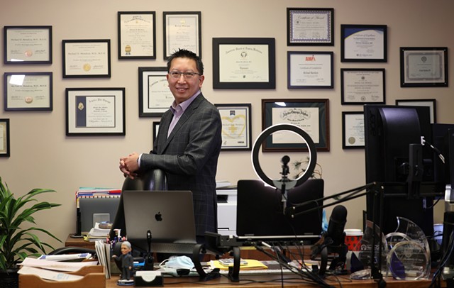 Monroe County Public Health Commissioner Dr. Michael Mendoza in his office at the county Health Department. His wall of citations has become a familiar backdrop for his frequent video news briefings during the pandemic.