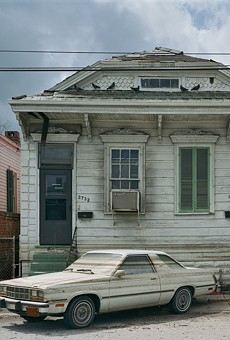 After the floods receeded, watermarks stain a car and houses in post-Katrina New Orleans. This photograph is part of "Robert Polidori: Chronophagia," which is on view at the Memorial Art Gallery through July 24.