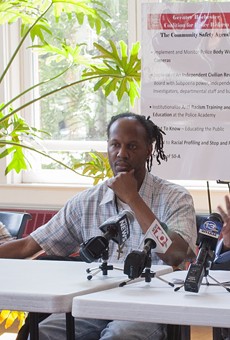 Christopher Pate (center) with his mother and the Rev. Lewis Stewart at a news conference in early August.