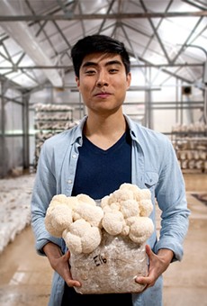 George Zheng, co-founder and COO of Leep Foods, holds a fruiting Lion’s Mane mushroom at the company’s grow warehouse.