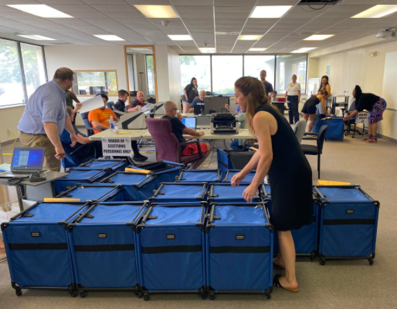 Monroe County Board of Elections officials move sealed blue ballot bins into place before beginning their recount on Tuesday, July 6, 2021.